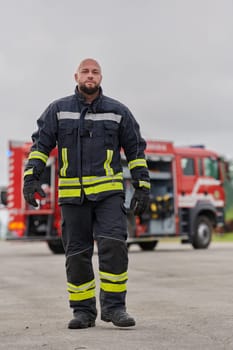 A symbolically brave firefighter strides forward with unwavering courage, epitomizing dedication and leadership, while behind him, a modern firetruck stands ready for firefighting actions, capturing the essence of heroism and preparedness in the face of emergency.