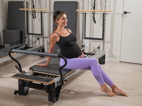 Pregnant woman resting after Pilates on a reformer machine