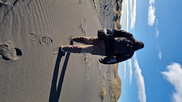 Tourist enjoying walk in iceland circa March 2023, admiring famous beach with wintry weather in northern region. Traveller taking scenic route to see majestic icelandic shoreline.