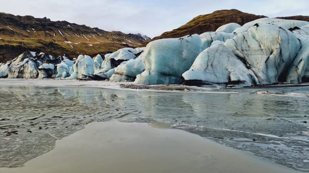 Huge vatnajokull glacier ice chain, fantastic blue rocks forming glacier lagoon near frozen lake in iceland. Spectacular nordic icebergs with crevasse and glacial ice caves.