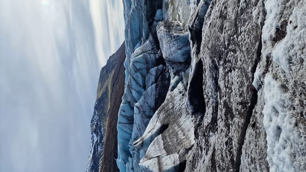 Glacier hiking vatnajokull ice cap in iceland with freezing cold icy blocks on scandinavian big lake, icelandic landscape. Majestic arctic icebergs near brown frosty hills and snowy fields.