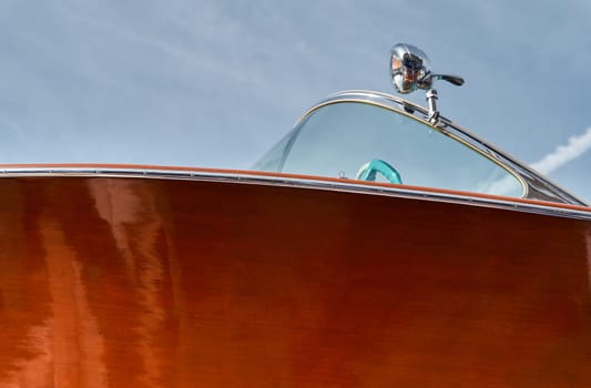 the wooden side of the luxury motor boat in port of Hercules in Monaco, sunny glare of the sun, elegance boat, glossy surfaces shine in sunny weather. High quality photo