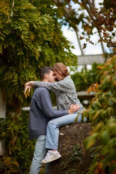 Young Cute Female Hugs Boyfriend. In Autumn Outdoor. Lovers Walking in Park. Attractive Funny Couple. Lovestory in Forest. Man and Woman. Cute Lovers in the Park. Family Concept. Happy Couple.