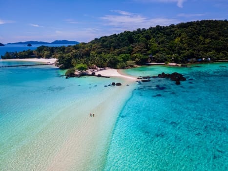 couple walking at the beach of Koh Kham Trat Thailand on a sunny day, men and woman on the beach drone aerial view