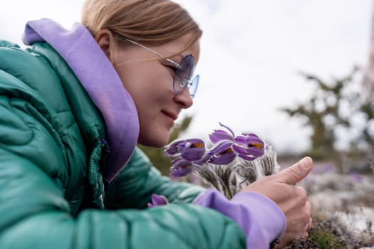 Dream grass woman spring flower. Woman lies on the ground and hugs flowers pasqueflower or Pulsatilla Grandis flowers.