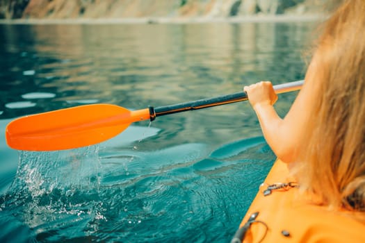 Kayak paddle sea vacation. Person paddles with orange paddle oar on kayak in sea. Leisure active lifestyle recreation activity rest tourism travel.