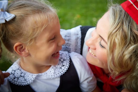 Young and adult schoolgirl on September 1. Generations of schoolchildren of USSR and modern Russia. Female pioneer in red tie and October girl in modern uniform. Daughter and Mother having fun