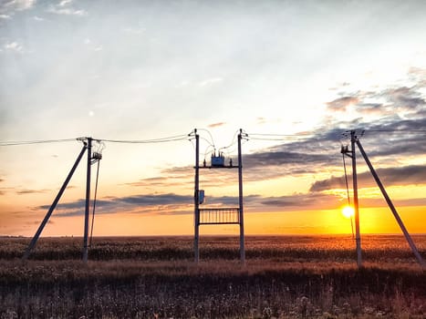 Old power poles and the sky with clouds in the background. Electric lines, towers, wires in landscape