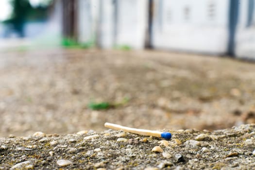 A match, a hand with matches against the background of old garages in city.