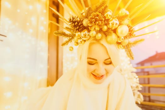 A woman in a white dress is holding a gold box with a red ribbon. She is wearing a crown on her head. The scene takes place in a room with a door and a window. The woman appears to be opening the gift box.