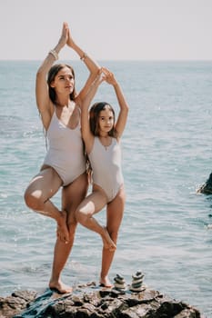 Silhouette mother and daughter doing yoga at beach. Woman on yoga mat in beach meditation, mental health training or mind wellness by ocean, sea