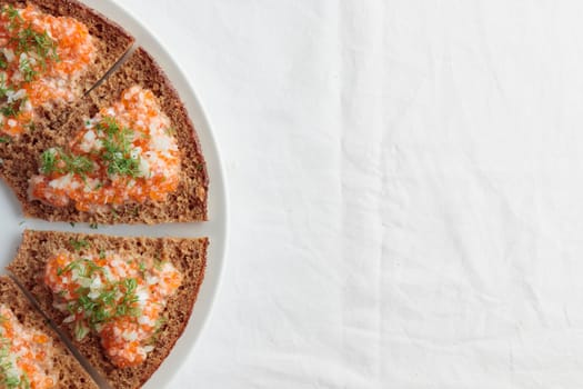 Homemade appetizer with red caviar, sour cream, dill, onion and rye bread on the white table - the traditional finnish recipe for a holiday food, flat lay in minimalistic style, healthy eating concept, horizontal with copy space