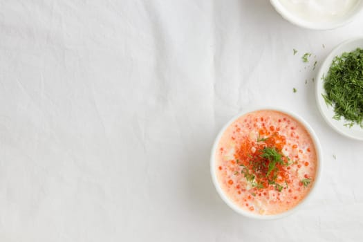 Homemade appetizer - Red caviar with sour cream, dill and onion - the finnish recipe for a holiday food, flat lay on the white table in minimalistic style with copy space, healthy eating concept, horizontal with copy space