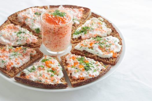 Homemade appetizer with red caviar, sour cream, dill, onion and rye bread on the white table - the traditional finnish recipe for a holiday food, in minimalistic style, healthy eating concept, horizontal