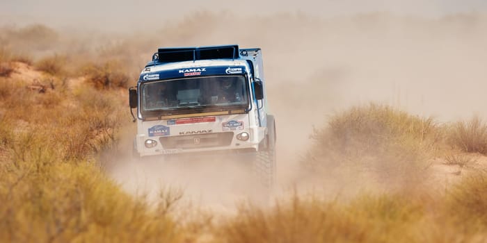 Extreme off-road racing. Sports truck KAMAZ gets over the difficult part of the route during the Rally raid in sand. 14.07.2022 Kalmykia, Russia.