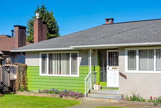 Entrance of residential house with small patio in front on a bright sunny day