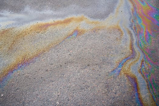 Spills of fuel or oil on the asphalt road as texture or background.