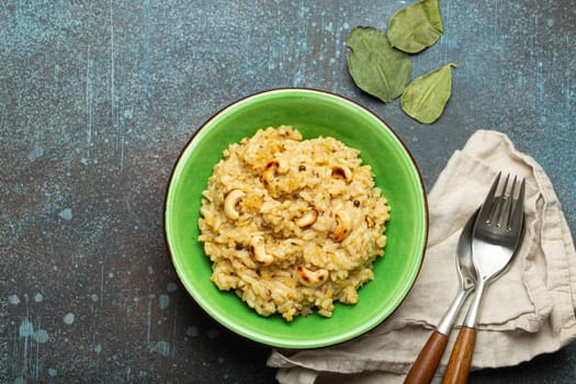 Ven Pongal (Khara Pongal), traditional Indian savoury rice dish made during celebrating Pongal festival, served in bowl top view on concrete rustic background.