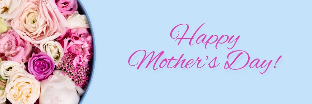 Happy mother's day picture. Blue background with hat box and flowers.