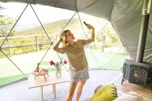 woman with smartphone in dome tent.