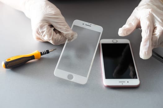 a person places a protective glass or film on a smartphone. copy space