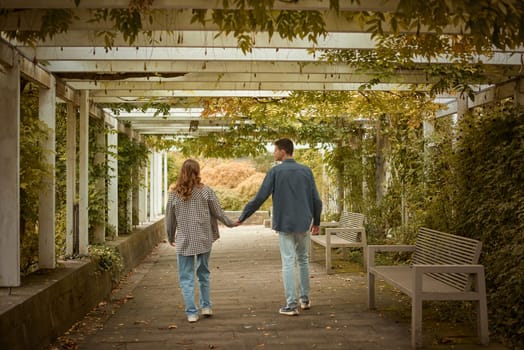 Young Cute Female Hugs Boyfriend. In Autumn Outdoor. Lovers Walking in Park. Attractive Funny Couple. Lovestory in Forest. Man and Woman. Cute Lovers in the Park. Family Concept. Happy Couple.