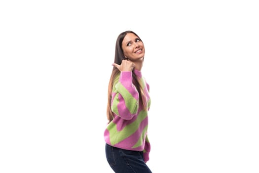 young happy caucasian woman with straight black hair is dressed in a stylish striped pink pullover.