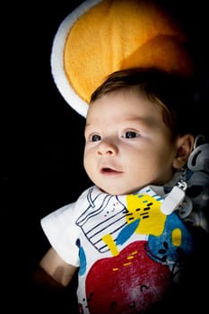 Two month old baby lying on a towel. Happy expression