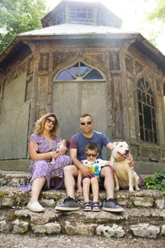 Family consisting of parents and two children. Sitting on some stairs.