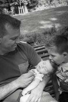 Four year old boy kissing his two month old brother. Sweet scene