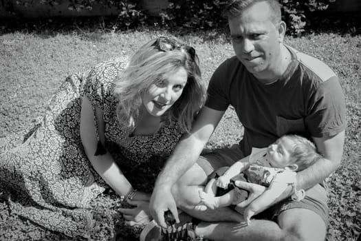 Family sitting on the grass. Summer day