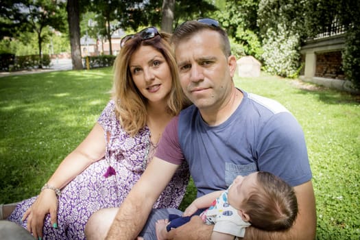 Family sitting on the grass. Summer day