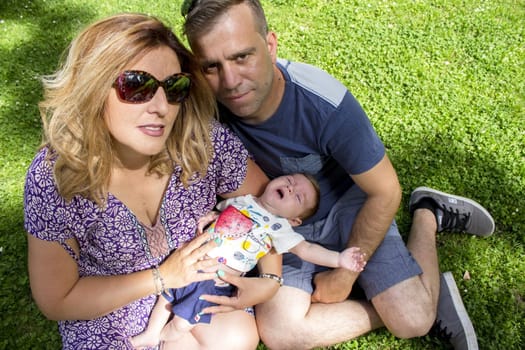 Family sitting on the grass. Summer day