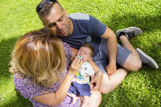 Family sitting on the grass. Summer day