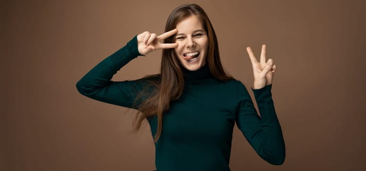 Successful 30 year old business woman with brown eyes wearing a green turtleneck on a brown background.