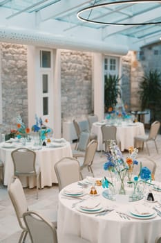 Laid festive tables in a restaurant with round lamps on the ceiling. High quality photo