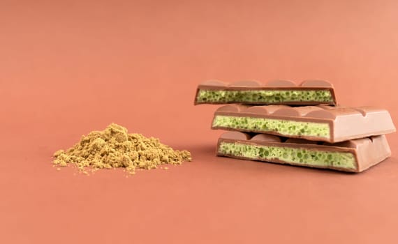 Stack of Chocolate Bar Pieces with THC and CBD oil and Medical Marijuana or Hemp Powder on Brown Background. Cannabis Dessert High quality photo