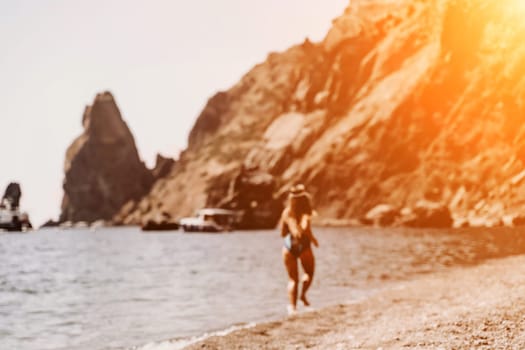 Woman travel summer sea. A happy tourist in a blue bikini enjoying the scenic view of the sea and volcanic mountains while taking pictures to capture the memories of her travel adventure