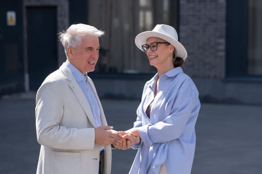 Stylish elderly laughing couple on a walk. Romantic relationships of mature people