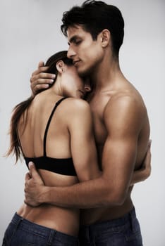 Couple, body and hug with skin in studio, topless and sensual with tender moment on white background. People together for fashion or beauty with intimacy, wellness and embrace, love and romance.