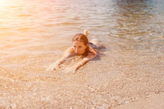 Woman travel sea. Young Happy woman in a long red dress posing on a beach near the sea on background of volcanic rocks, like in Iceland, sharing travel adventure journey