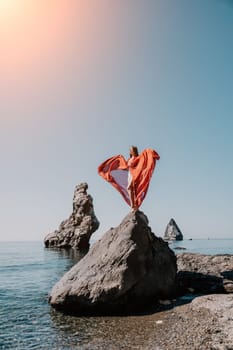 Woman travel sea. Happy tourist taking picture outdoors for memories. Woman traveler looks at the edge of the cliff on the sea bay of mountains, sharing travel adventure journey.