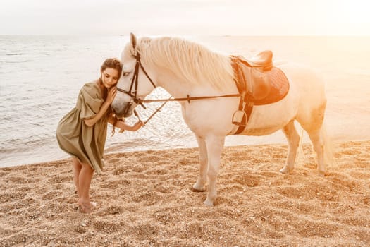 A woman in a dress stands next to a white horse on a beach, with the blue sky and sea in the background
