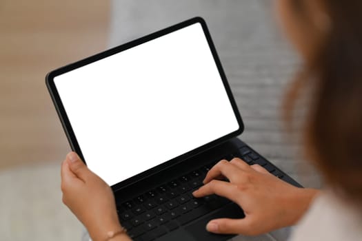 Smiling young woman in casual clothes browsing internet on digital tablet. People and technology concept.