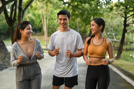 Shot of young people in sports clothing jogging in the city park. Healthy Lifestyle concept