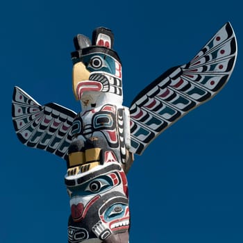 Isolated totem wood pole in the blue background