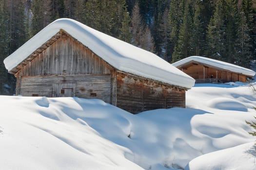 Isolated wood mountain house cabin hut covered by snow 