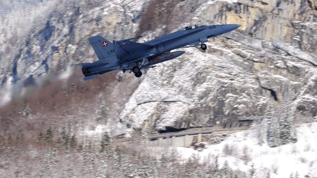 Meiringen Switzerland January 19 2023: Modern supersonic air defense jet lifts off against a spectacular snowy mountain panorama for security mission for World Economic Forum WEF in Davos. Copy Space