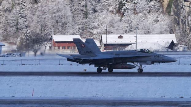 Switzerland January 19 2023: F-18 Hornet of Swiss Air Force taxiing on runway in enchanting snowy landscape of Meiringen airport ready for winter mission during the World Economic Forum WEF in Davos