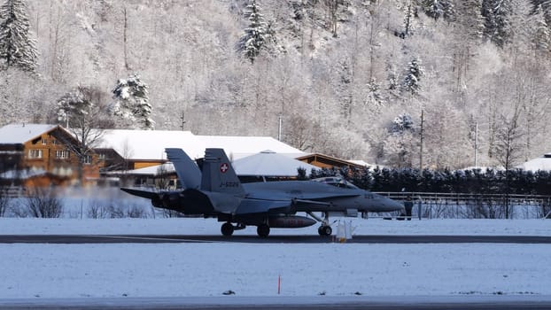 Meiringen Switzerland January 19 2023: Armed fighter jet provide air defense during the World Economic Forum WEF in Davos. Copy Space. Boeing F-18 Hornet of Swiss Air Force. White winter snow scenario